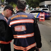 Agentes da Balada Segura do DetranRS, um de lado no canto esquerdo da foto e outro de costas ao centro, durante blitz da Balada Segura